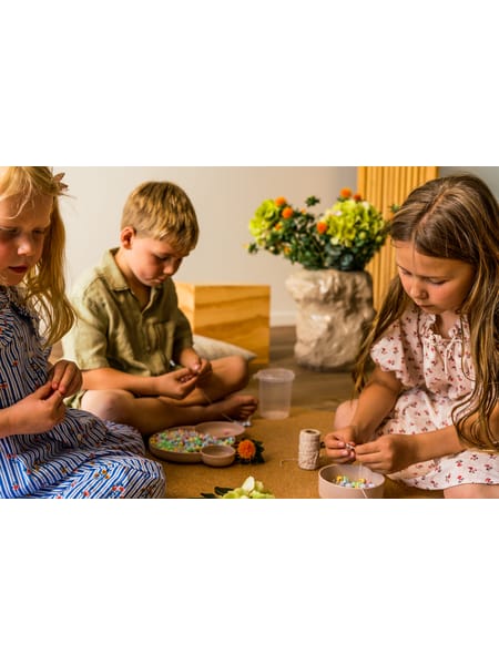 Rund gennemsigtig beholder med små pastellfarvede perler